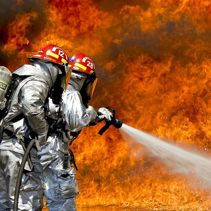 two firefighters fighting a blaze