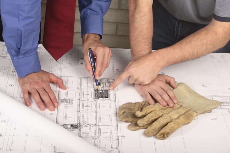 three people looking at costs on table