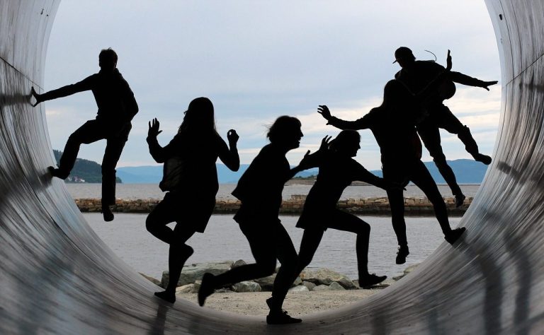 People dancing or running inside a large cylinder