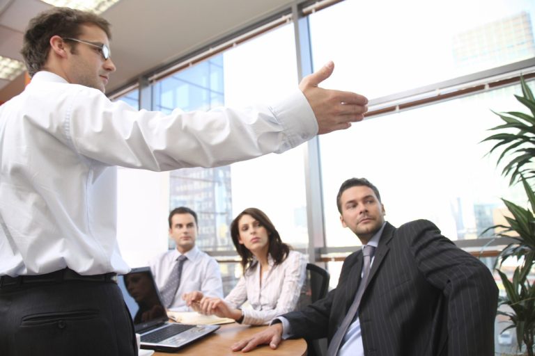 man presenting to three colleagues
