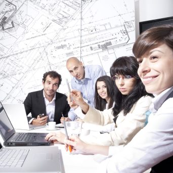 Men and women in meeting with laptops